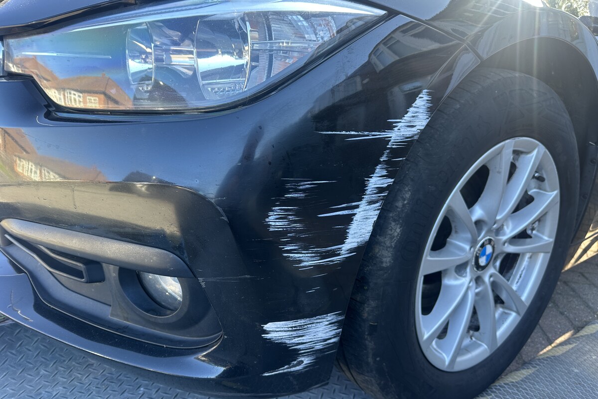 Scratched black bumper before repair